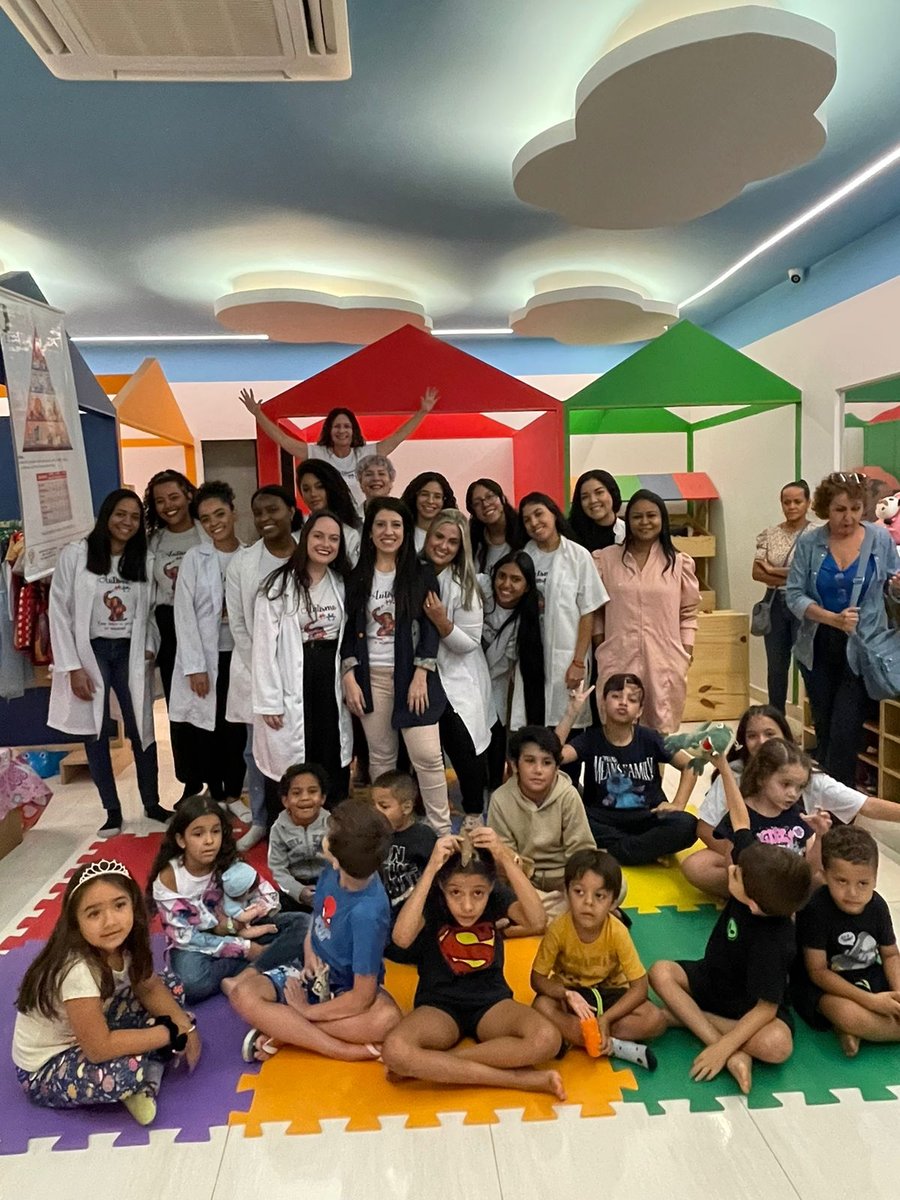 Equipe da Clínica CEPAI com as crianças na sala lúdica colorida